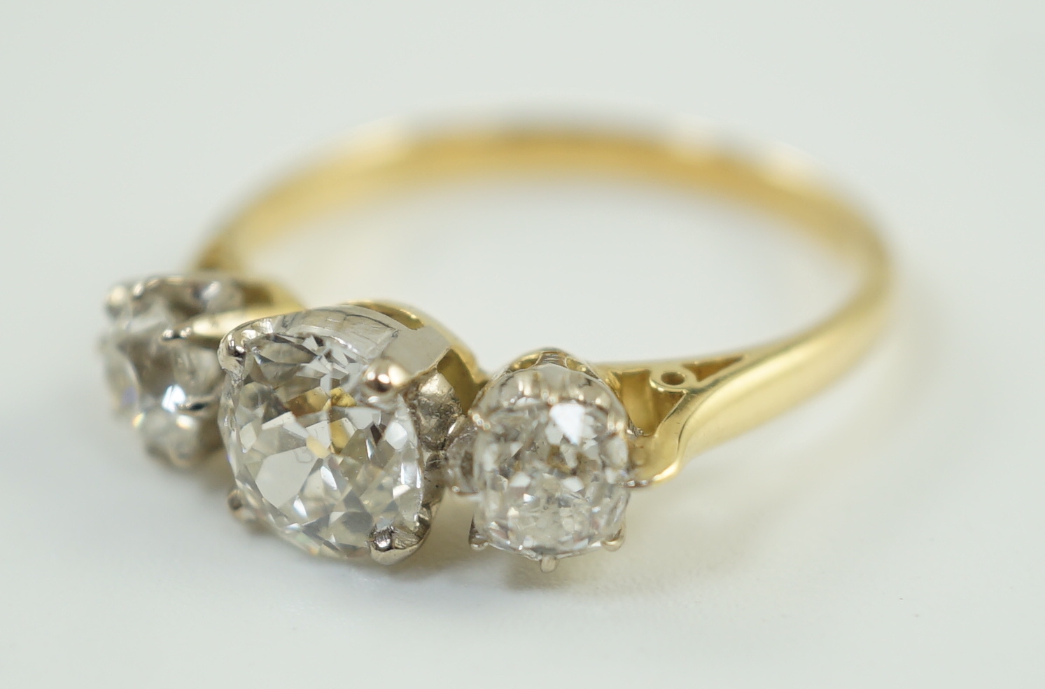 A modern 18ct gold and three stone diamond set ring